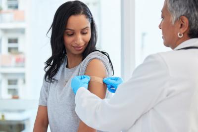 Female doctor putting a band-aid on a woman