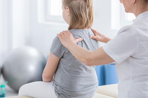 child, therapist, examining back