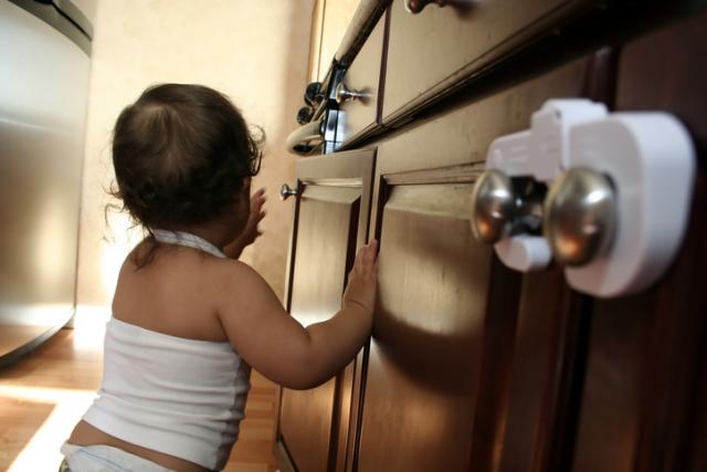 child exploring kitchen cabinet