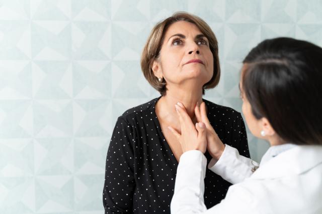doctor checking thyroid