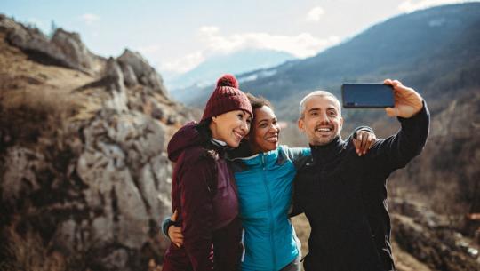 group of friends taking selfie on mountain