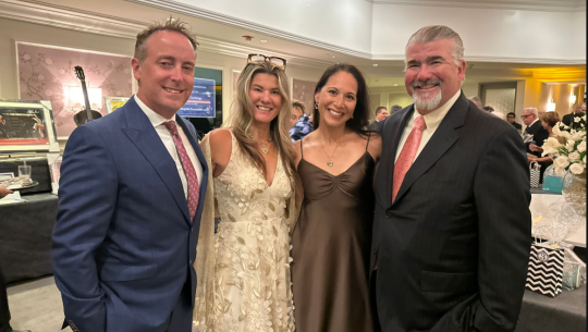 4 members of the Bahnik family stand in a line together at an event