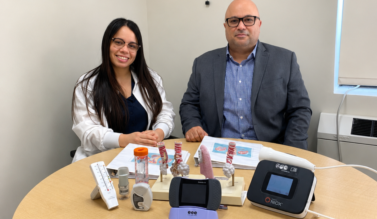 A man and woman sit at a round table with COPD devices