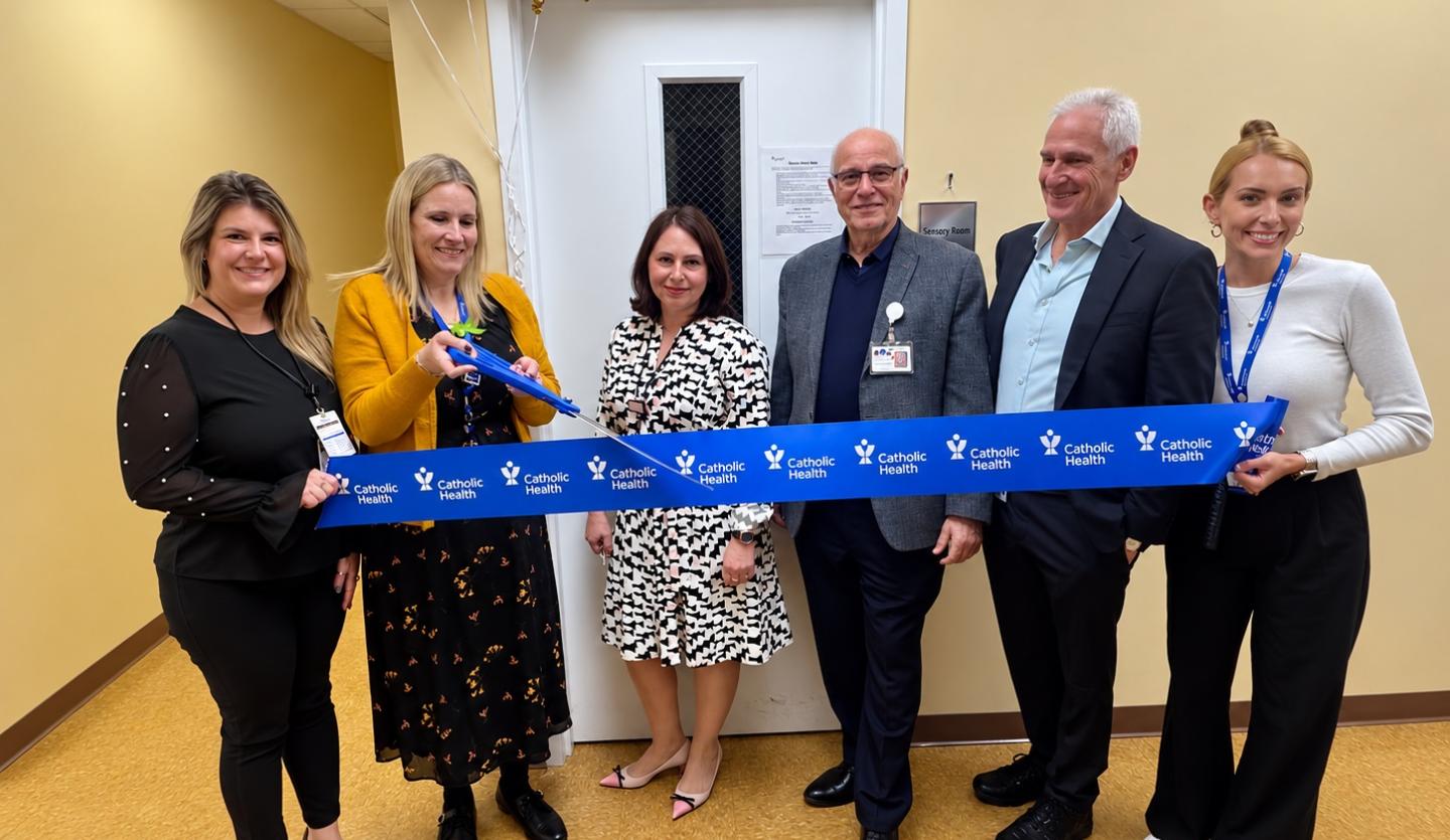 6 people stand together to cut a Catholic Ribbon