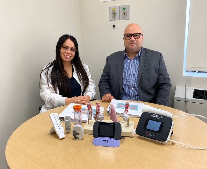 A man and woman sit at a round table with COPD devices