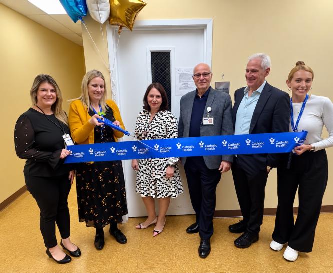 6 people stand together to cut a Catholic Ribbon