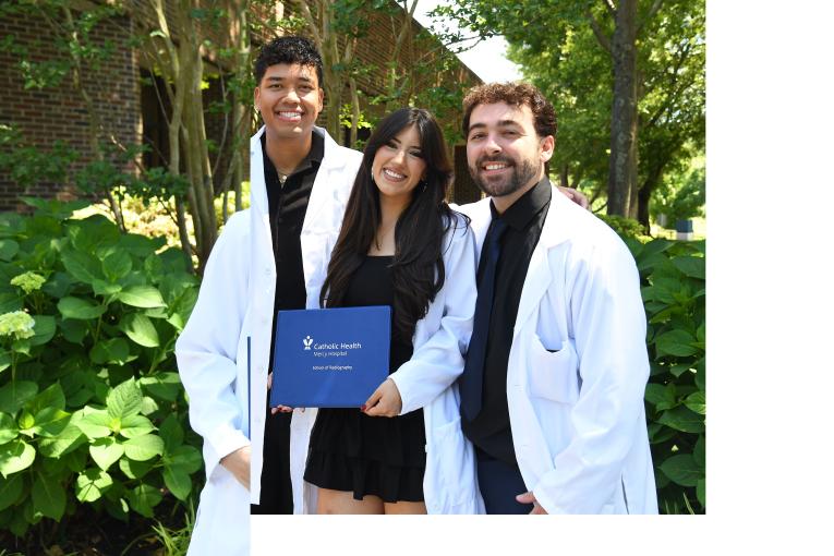 2 students in white lab coats stand together at the Mercy Hospital School of Radiology Graduation