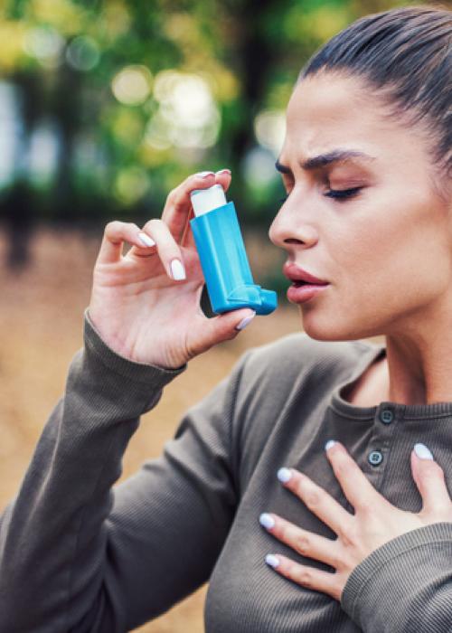 person using asthma inhaler