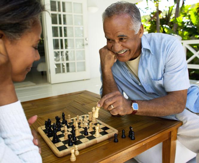 man, woman playing chess