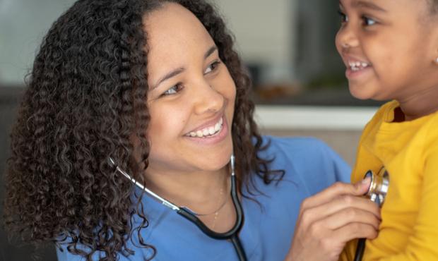 doctor with young girl, listening with stethoscope 