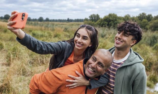 Parent poses with children for a selfie